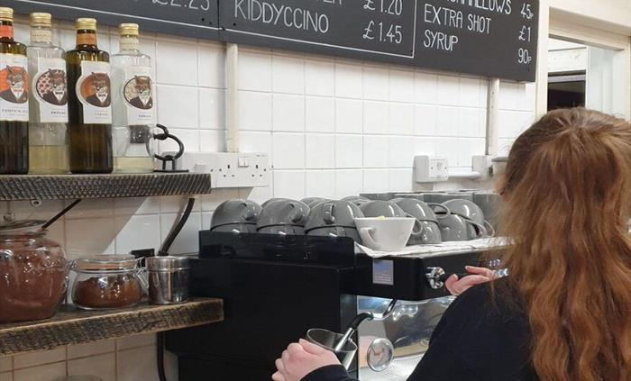 A barista making freshly ground coffee
